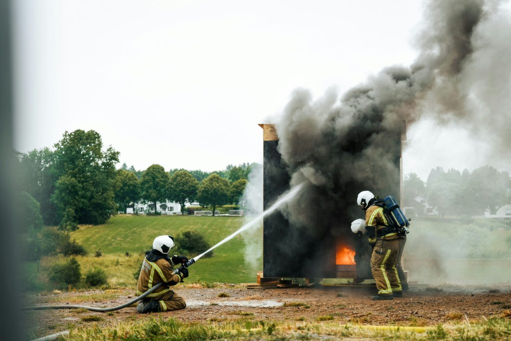 Ein paar Feuerwehrleute löschen einen Brand